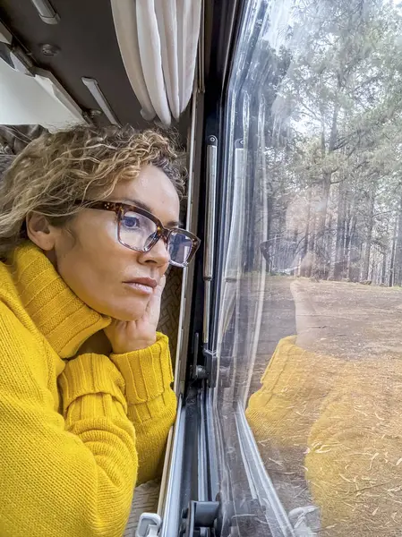 Kobieta Okularach Żółtym Swetrze Relaksuje Się Patrząc Przez Okno Pani — Zdjęcie stockowe