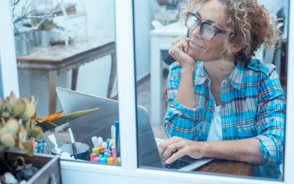 Smilende Kvinne Innsjekket Skjorte Som Jobber Laptop Mens Hun Sitter – stockfoto