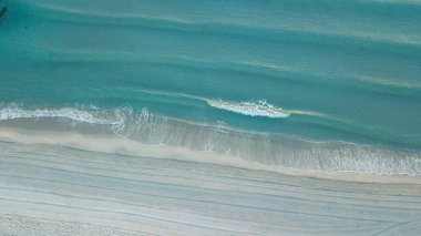 Görüntü yaz plajının yukarısından alındı ve açık mavi ve turkuaz deniz.