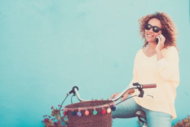 Bisikletli, şehirde çekici bir kadın telefonda konuşurken kendini huzurlu ve rahat hissediyor. Bisiklet süren kadınların karbon ayak izlerini azaltmak için çevre dostu ulaşım