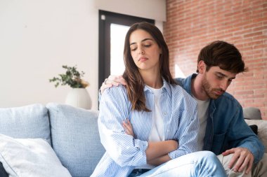 Üzgün ve düşünceli bir kız. İlişki sorunlarını düşünüyor. Gücenmiş erkek arkadaşıyla koltukta oturuyor.. 