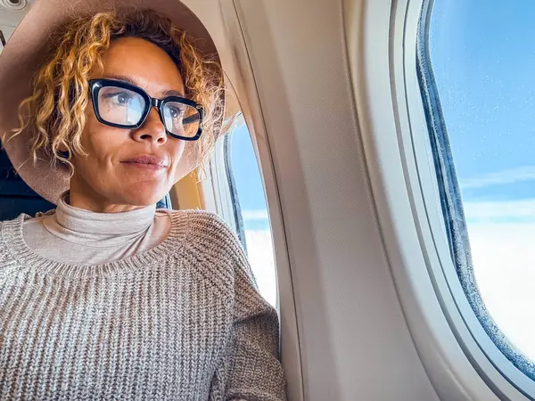 Éves Szőke Szemüvegben Egy Repülőgép Ülésén Kinézve Ablakon Mosolyog Élvezi Stock Kép