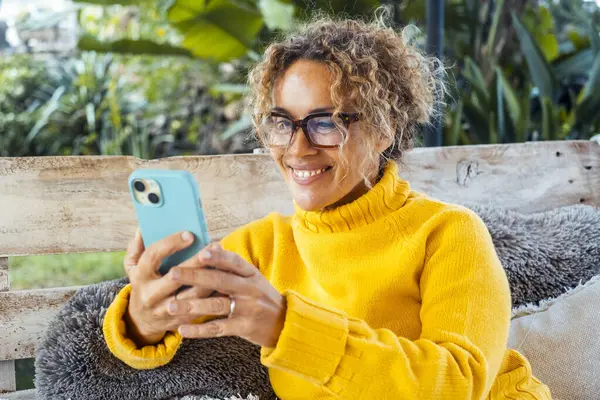 Een Vrouw Gebruikt Haar Mobiele Telefoon Ontspant Zich Alleen Tuin Stockfoto