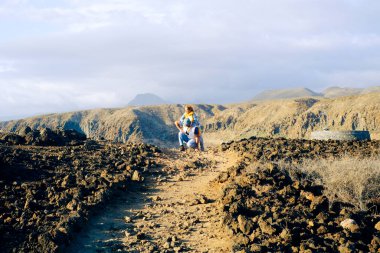 Aktif çiftler volkanik manzara hedeflerinde birlikte gezintiden hoşlanırlar. Seyahat eden insanların yaşam tarzları. Macera ve dışarıda aktif bir yaşam tarzı. Dağ ve gökyüzü arka planı