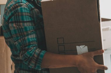 Mutlu bir kadın gülerek eski karton kutuyu yeni evine taşıyor. Dairenin yeniden yerleştirilmesi, ipotek konsepti, ev içi boş zaman aktivitesi kadın insanları. Bağımsızlık ve yalnız yaşamak.