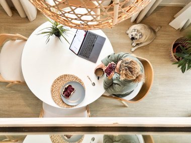 Sabah hayat tarzında kahvaltı yapan bir kadının dikey görüntüsü.