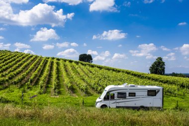 Modern karavan karavanı bir üzüm bağında park ediyor. Vanlife tarzı ve seyahat macerası. Eğlence aracıyla alternatif tatil tatili. Tekerlekli küçük bir ev. Campervan