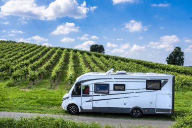 Modern karavan karavanı bir üzüm bağında park ediyor. Vanlife tarzı ve seyahat macerası. Eğlence aracıyla alternatif tatil tatili. Tekerlekli küçük bir ev. Campervan