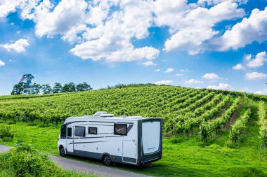 Modern karavan karavanı bir üzüm bağında park ediyor. Vanlife tarzı ve seyahat macerası. Eğlence aracıyla alternatif tatil tatili. Tekerlekli küçük bir ev. Campervan