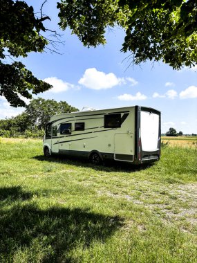  Kamyon. Büyük karavan. Kırsal kesimde çimlerin üzerinde park edilmiş. Özgürlük ve seyahat alternatif yaşam tarzı. Yaz tatili için nakliye aracı. Vanlife ve grid dışında yaşamak