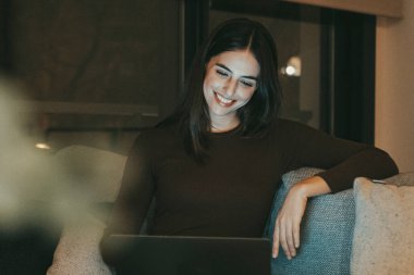 Modern çağın genç kadını geceleri dizüstü bilgisayarda çalışıyor evdeki ya da otel odasındaki kanepede oturuyor. Çevrimiçi seyahat eden insanları bilgisayarla kaydetmek. İnternete bakıyorum, eğleniyorum ve içeriğinden keyif alıyorum.