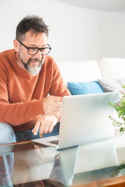  Yetişkin bir adam bilgisayarını takım çalışması kumandasıyla görüntülü aramayla meşgul ediyor. İş görüşmeleri için bilgisayarın önünde konuşmak. Zeki çalışan ve danışman serbest çalışan profesyonel erkek online