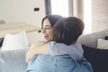Yeni evlerinde kucaklaşan güzel genç bir çift. Nişanlı çiftler yeni evleri için birbirlerine mutlu bir şekilde sarılarak kutluyorlar..