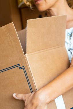 Mortgage emlak konseptini taşımak için karton kutu tutan yetişkin bir kadının karyolasını kapatın. İnsanların taşındığı yeni yaşam evi macera konsepti. Borç.