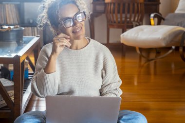 Mutlu bir kadının dizüstü bilgisayar kullanması ve çözüm için düşünmesi ya da gülümseyerek yukarı bakmayı hayal etmesi. Hayal kuruyorum. Bir sonraki seyahat iznini internetten ayarlıyorum. Küçük işletme fikriyle uzaktan kumandayla evde çalışmak