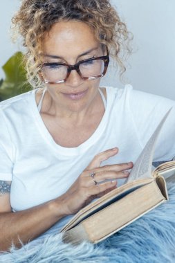 Sakin bir kadın evde rahatlama aktivitesi üzerine kitap okuyor. Tek başına. Sağlıklı olmak ve oturma odasında dinlenmek. Dişi insanlar pazar günleri yerde oturup kitap okuyup eğleniyorlar. Mutlu yaşam tarzı bayan.