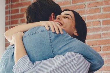 Kapalı gözlerle mutlu bir şekilde gülümseyen mutlu çiftin yakın çekimi, modern evdeki hassas anın tadını çıkarması, gülümseyen eş ve genç kocanın kucaklaşması, kucaklaşması, evde romantik bir randevu.