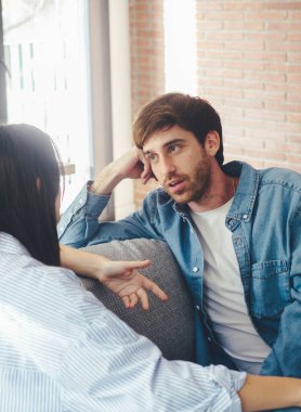 Ciddi genç bir çift kanepede birlikte oturuyor, ilişkiler hakkında konuşuyor, evde birlikte vakit geçiriyorlar, konsantre bir koca eşinin konuşmasını dinliyor, arkadaşlarıyla sohbet ediyor.