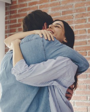 Kapalı gözlerle mutlu bir şekilde gülümseyen mutlu çiftin yakın çekimi, modern evdeki hassas anın tadını çıkarması, gülümseyen eş ve genç kocanın kucaklaşması, kucaklaşması, evde romantik bir randevu.