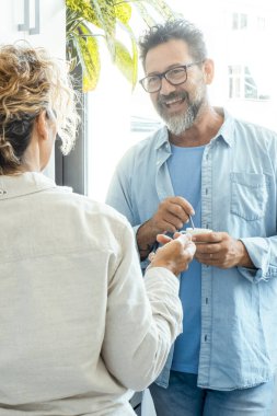 Mutfakta birlikte kahve içen mutlu tartışma çifti. Bir erkek ve bir kadın kapalı bir yerde konuşuyor ve gülümsüyor. Günlük eğlence aktiviteleri. Yetişkin insanlar iyi bir ilişki yaşam tarzını seviyor.