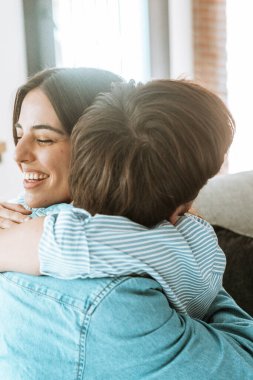 Neşeli genç çift özel bir anda mutlu bir ifadeyle kucaklaşıyorlar. Fotoğraf, bir yıldönümü kutlamasının heyecanını ve birlikte yaşama teklifinin kabul edilmesini yansıtıyor. Derin aşkı ya da eğlenceli bir arkadaşlığı yansıtıyor.