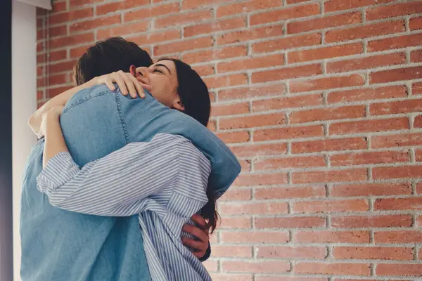 stock image Heartwarming moment of a woman joyfully embracing her partner after he proposes. The scene captures the emotional happiness of an engagement, with two people celebrating together at home, filled with love and excitement