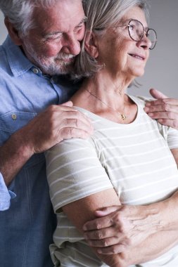 Evlerinin arkasından kucaklaşan yaşlı bir çiftin hayalperest ve sevgi dolu ifadeleri. Yaşlı adam, olgun karısını koruma ve şefkat ile sarar ve ömür boyu süren evlilikten sonra ebedi aşklarını gösterir.