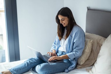 Yetişkin bir Womqan dizüstü bilgisayarını kullanarak iş ya da boş zaman aktivitesi için dinleniyor. Arkadaşlarla sohbet, internet bağlantısı. İnsanlar ve teknoloji. Uzaktan kumandalı otel çalışanı.