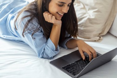 Yatak manifatura laptop yatan, erkek arkadaşıyla sohbet veya romantik mektubu mutlu kız kadın ileti web sörf, internet tarama kadın yatak odasında rahatlatıcı arkadaşlarınızla konuşurken gülümseyen