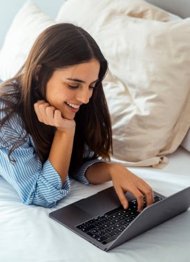 Yatak manifatura laptop yatan, erkek arkadaşıyla sohbet veya romantik mektubu mutlu kız kadın ileti web sörf, internet tarama kadın yatak odasında rahatlatıcı arkadaşlarınızla konuşurken gülümseyen