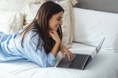 Yatak manifatura laptop yatan, erkek arkadaşıyla sohbet veya romantik mektubu mutlu kız kadın ileti web sörf, internet tarama kadın yatak odasında rahatlatıcı arkadaşlarınızla konuşurken gülümseyen