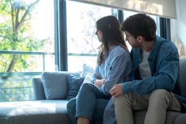 Oturma odasında birbirlerinden uzak oturan bunalımlı erkek ve kadın ilişki sorunları, güven sorunları, aldatma, maddi baskı ve duygusal sıkıntı ile boğuşuyorlar.