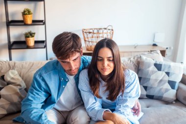 Genç bir çift oturma odasında birlikte TV şovundan zevk alıyor, kanepede oturuyor, bir yayın servisi aracılığıyla bir dizi izliyor, istek üzerine eğlendirici ve eğlenceli bir öğleden sonra geçiriyor.