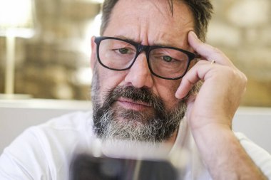 Evde ciddi bir adam var. Telefonunu kullanarak alarm veren bir e-postayı okuyor. İnternette gezinirken algılama güçlüğü çekiyor, sosyal medyada geziniyor ve soruna çözüm arıyor.