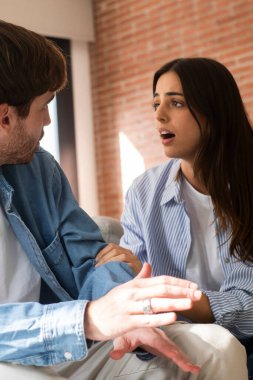 Evdeki kanepede oturan erkek ve kadın, ihanet ve sadakatsizlikten sonra ciddi ilişki zorluklarıyla yüzleşiyor, sevgi ve finansal stres kaybıyla mücadele ediyor ve gelecekleri hakkında birlikte zor kararlar veriyorlar.