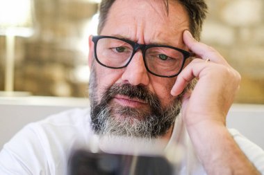 Evde ciddi bir adam var. Telefonunu kullanarak alarm veren bir e-postayı okuyor. İnternette gezinirken algılama güçlüğü çekiyor, sosyal medyada geziniyor ve soruna çözüm arıyor.