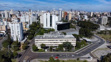 Güneşli bir günde Parana eyaletinin başkenti Curitiba 'ya bakan insansız hava aracı. Resmin altında Parana Yasama Meclisi, Parana Yasama Gücü 'nün merkezi..