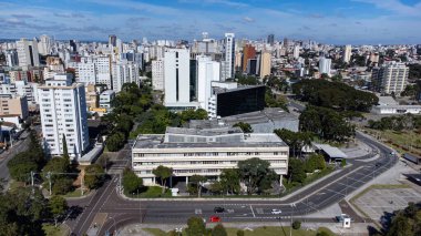 Güneşli bir günde Parana eyaletinin başkenti Curitiba 'ya bakan insansız hava aracı. Resmin altında Parana Yasama Meclisi, Parana Yasama Gücü 'nün merkezi..