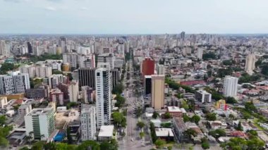 Güneşli bir günde Curitiba 'nın orta kesimindeki binaları gösteren hareket halindeki bir insansız hava aracıyla video..