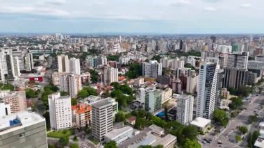 Güneşli bir günde Curitiba 'nın orta kesimindeki binaları gösteren hareket halindeki bir insansız hava aracıyla video..