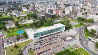 İnsansız hava aracı, Iguacu Sarayı 'nın açık bir görüntüsüyle başlıyor, İcra Şubesi' nin merkezi, ve daha sonra Curitiba 'daki Paran Yasama Meclisi, Yasama Şubesi' nin merkezi, ortaya çıkana kadar dönüyor..