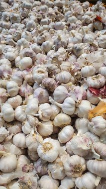 Farklı şekil ve boyutlarda birkaç sarımsak başlığı olan pazar rafı..