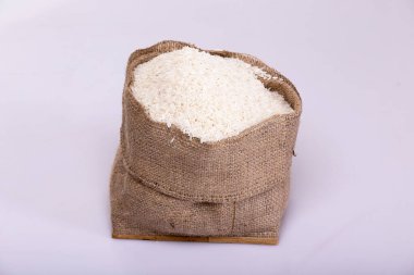 Beyaz arka planda beyaz tabakta pirinç. Tahta kasedeki pirinç..