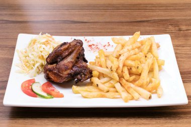 Masada kızarmış tavuk kanadı ve patates kızartması.