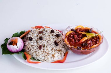 ... etli, sebzeli ve sebzeli pirinç, beyaz bir tabakta, beyaz bir arka planda.