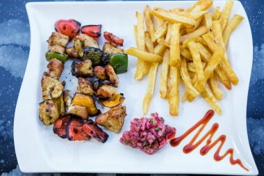 Beyaz tabakta ızgara tavuk ve sebze..