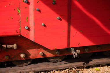 Kırmızı tekerlekleri olan eski ahşap bir araba.