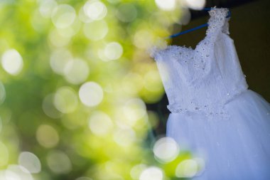 bir bahçede asılı beyaz gelinlik