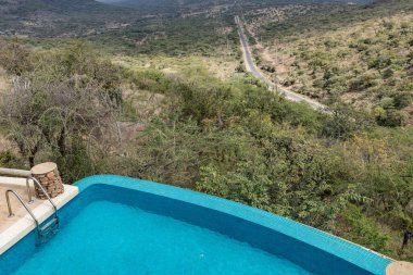 Üzerinde şelale olan yüzme havuzu manzarası.