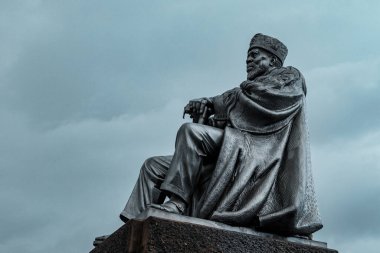 Bulutlu bir günde parkta bir kralın anıtı.